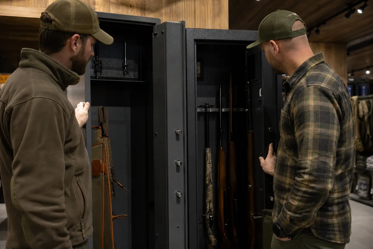 Jägare jämför dokumentation och märkning på två vapenskåp i en butik